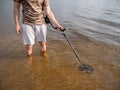 Guy in the river is looking for treasure with a metal detector in the water Royalty Free Stock Photo