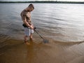 Guy in the river is looking for treasure with a metal detector in the water Royalty Free Stock Photo