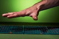 The guy's hand is over a green massage mat in a unfolded view on a green background. Advertising, thematic and subject shooting.