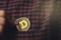 The guy& x27;s hand puts a Dogecoin coin in his pocket, a cryptocurrency dogecoin