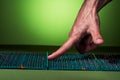 The guy `s hand touch on a green massage mat in twisted form on a green background. Advertising and subject shooting. For