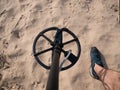 Guy on a sandy ground with a metal detector looking for treasure on a sunny summer day Royalty Free Stock Photo