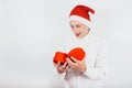 A guy in a Santa hat in the New Year is holding a gift in his hands, a red box. A man looking in a box Royalty Free Stock Photo