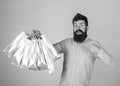 Guy shopping and pointing at bags. Recommendation concept. Hipster on surprised face recommends to buy. Man with beard Royalty Free Stock Photo