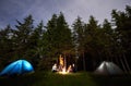 Guy is showing his friends the starry sky over tent city. Outdoor recreation