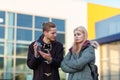 The guy shows the broken phone to the girl on a blurred background