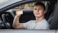 Guy shows the driver license out of the car window Royalty Free Stock Photo