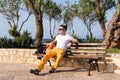 Guy sitting on a bench near the sea