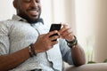 Guy sitting on couch closeup focus on hands holding smartphone