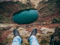 Guy sitting on the edge of a crater. Shot with legs and foot in picture