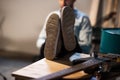 The guy is sitting with his feet in sneakers on the table, on the table is a bass guitar, close-up, a scene for product