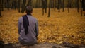 Guy sitting in park inspired by beautiful nature and thinking about past life