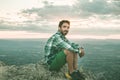 Guy sitting on a rock on the mountain watching a sunset. Social network style photo Royalty Free Stock Photo