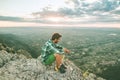 Guy sitting on a rock on the mountain watching a sunset. Social network style photo Royalty Free Stock Photo