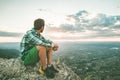 Guy sitting on a rock on the mountain watching a sunset. Social network style photo Royalty Free Stock Photo