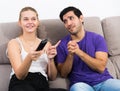 Guy begging girlfriend for TV remote Royalty Free Stock Photo