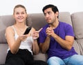 Guy begging girlfriend for TV remote Royalty Free Stock Photo