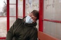 Guy sleeps at the bus stop in medical mask close-up respiratory viral disease protection flu covid-19 measles