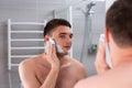 Guy smearing shaving gel on his face in the bathroom Royalty Free Stock Photo