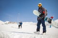 Snowboarder walking with a snowboard in the winter. Ski touring in the snowy mountains on a sunny day Royalty Free Stock Photo