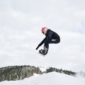 Male snowboarder doing tricks in the air at ski resort. Royalty Free Stock Photo