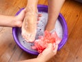 The guy in the spa salon made the girl a warm foot bath and washes her feet with natural and fragrant soap.aromatherapy for legs Royalty Free Stock Photo