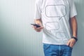 Guy with speech balloons printed on shirt using mobile phone Royalty Free Stock Photo