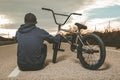 Guy standing bmx bike. BMX rider with and a sunset. Extreme urban sports Royalty Free Stock Photo