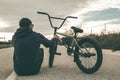 Guy standing bmx bike. BMX rider with and a sunset. Extreme urban sports Royalty Free Stock Photo