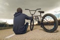 Guy standing bmx bike. BMX rider with and a sunset. Extreme urban sports Royalty Free Stock Photo