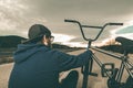 Guy standing bmx bike. BMX rider with and a sunset. Extreme urban sports Royalty Free Stock Photo