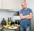 Guy stands proudly in kitchen hands clasped Royalty Free Stock Photo