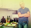 Guy stands proudly in kitchen hands clasped Royalty Free Stock Photo