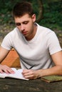 Guy and student takes notes in notebook, learning and writes thoughts, writes the book, he is preparing his final exams. Royalty Free Stock Photo