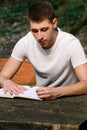 Guy and student takes notes in notebook, learning and writes thoughts, writes the book, he is preparing his final exams. Royalty Free Stock Photo