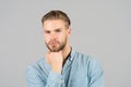 Guy with stylish hair touch beard with hand. Bearded man with healthy young skin. Macho with unshaven face and mustache. Beard gro Royalty Free Stock Photo