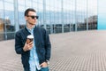 The guy in stylish sunglasses, a man walks around the city and drinking coffee from a paper Cup, a handsome guy walks around and r Royalty Free Stock Photo