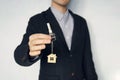 guy in the suit shows me the keys. Key chain in the form of a house in a man hand. Holding house keys on house shaped keychain Royalty Free Stock Photo