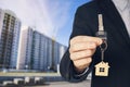 guy in the suit shows me the keys. Key chain in the form of a house in a man's hand. Holding house keys on house shaped keychain Royalty Free Stock Photo