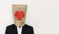 A guy in suit wearing brown paper bag with heath shape Royalty Free Stock Photo