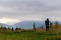 Guy takes pictures of beautiful autumn cloudy mountains on his phone