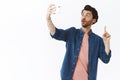Guy talking on video call using mobile app, sharing great idea with friend as gesturing, raise one finger eureka gesture Royalty Free Stock Photo