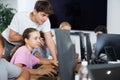 Guy teacher teaches girl student how to use computer Royalty Free Stock Photo