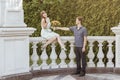 The guy theatrically gives a bouquet to his bride. Etude love in the park. Newlyweds on a sunny day with a bouquet Royalty Free Stock Photo