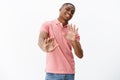 Guy think he pass. Uninterested african american man unwilling to participate in party raising hands near chest in no