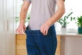 The guy trying on big jeans after losing weight. Man in oversized pants in weight loss concept Royalty Free Stock Photo