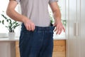 The guy trying on big jeans after losing weight. Man in oversized pants in weight loss concept Royalty Free Stock Photo