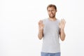 Guy trying refuse proposal being not in mood raising palms in rejection gesture clenching teeth and making sorry