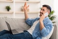 Guy using computer and talking on cellphone at home Royalty Free Stock Photo