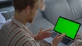 Guy using green laptop computer closeup. Online teacher talking video conference